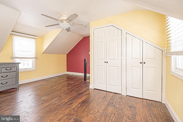 additional living space featuring vaulted ceiling, dark hardwood / wood-style floors, a wealth of natural light, and ceiling fan