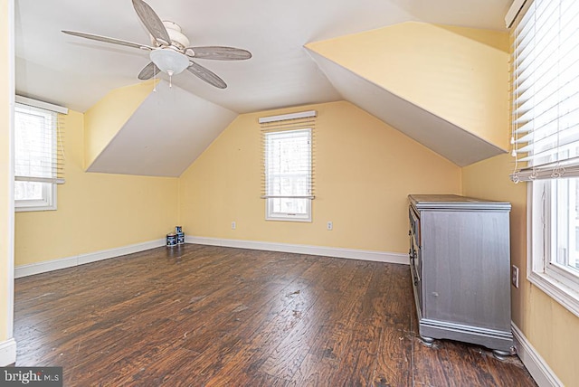 additional living space with ceiling fan, dark hardwood / wood-style floors, and vaulted ceiling