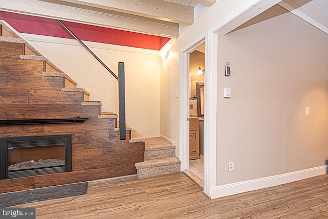 stairs with beam ceiling and hardwood / wood-style floors