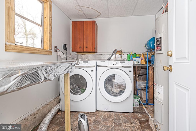 clothes washing area featuring cabinets, electric water heater, and washing machine and clothes dryer