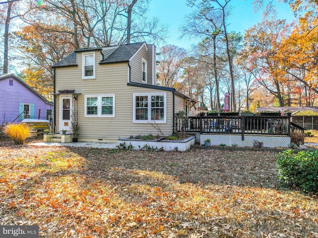 rear view of house with a deck and a lawn