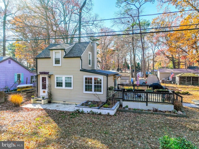 rear view of property with a deck and a lawn