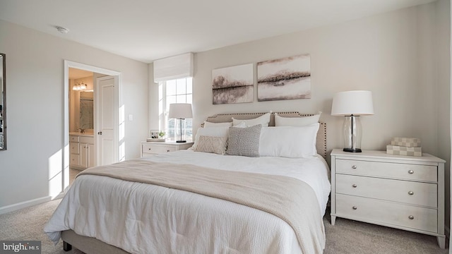 bedroom with light colored carpet and connected bathroom