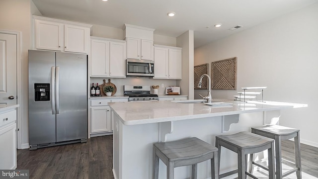 kitchen with white cabinetry, a kitchen island with sink, and appliances with stainless steel finishes