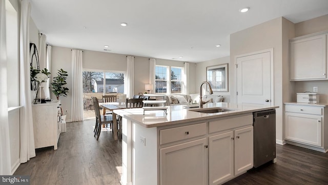 kitchen featuring dishwasher, sink, dark hardwood / wood-style floors, a center island with sink, and white cabinets