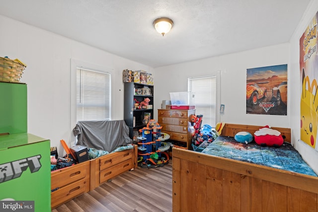 bedroom with a textured ceiling and light hardwood / wood-style floors