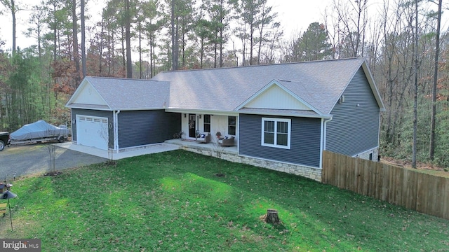 single story home featuring covered porch, a garage, and a front yard