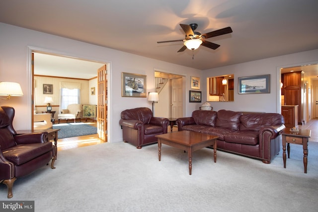 carpeted living room with ceiling fan