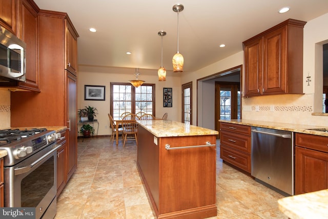 kitchen with pendant lighting, a center island, light stone counters, and appliances with stainless steel finishes