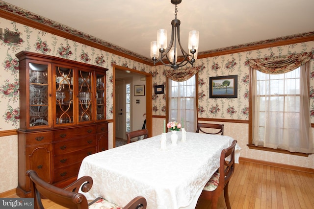 dining room with a chandelier, ornamental molding, and light hardwood / wood-style flooring