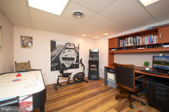 home office with a paneled ceiling and wood-type flooring