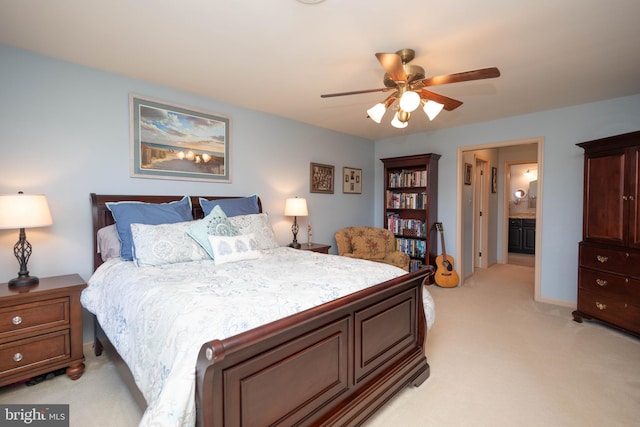 carpeted bedroom with ensuite bath and ceiling fan