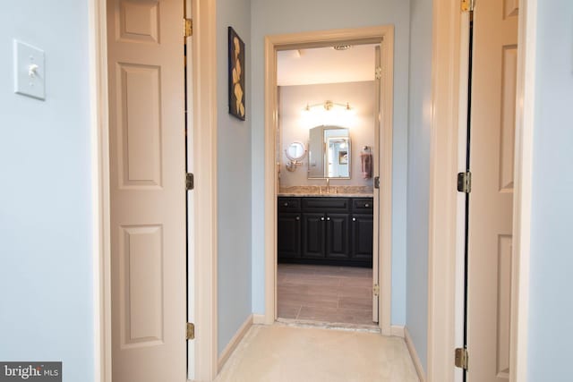 corridor featuring light hardwood / wood-style flooring and sink