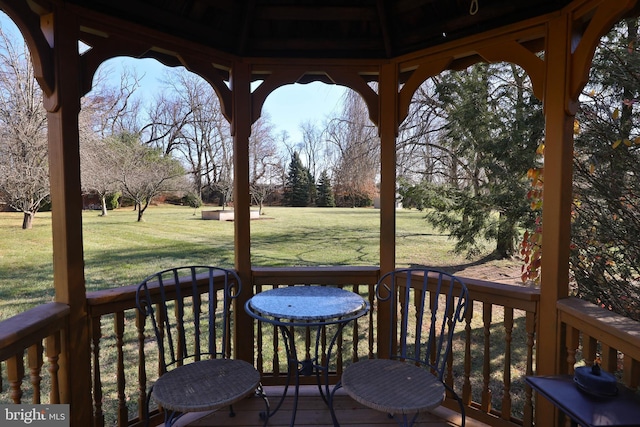 wooden terrace with a gazebo and a yard