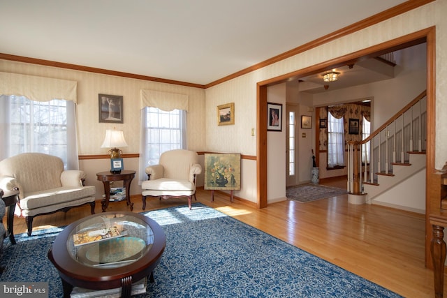 living room featuring a chandelier, wood-type flooring, and ornamental molding