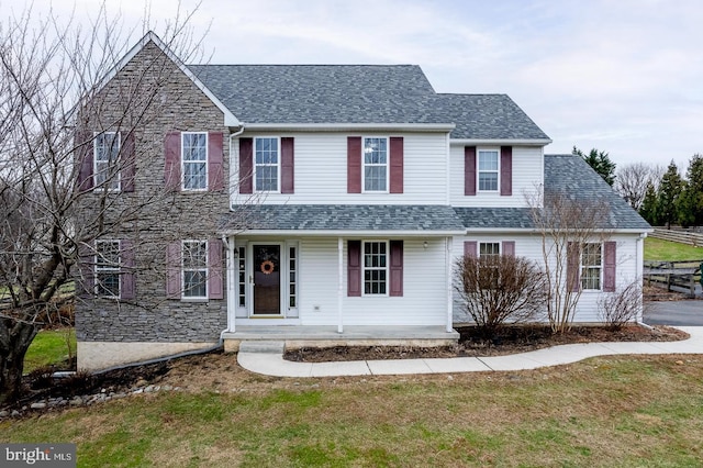 view of front of property featuring covered porch and a front yard