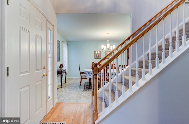 entryway with light hardwood / wood-style flooring and a chandelier