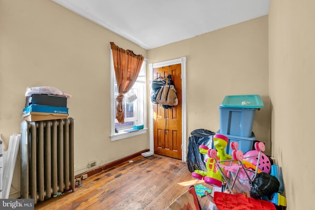 interior space with hardwood / wood-style flooring and radiator heating unit