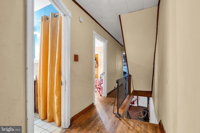 corridor with ornamental molding and light hardwood / wood-style flooring