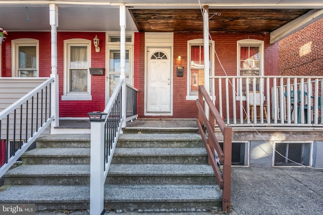 view of exterior entry featuring covered porch