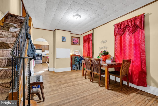 dining space with crown molding and light hardwood / wood-style flooring