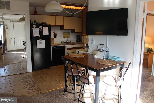 kitchen with sink, light colored carpet, and black appliances