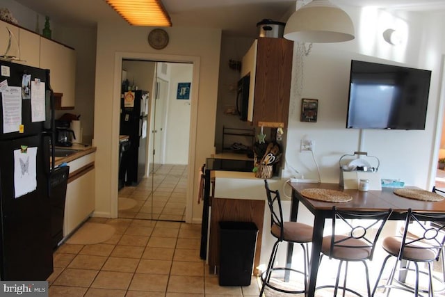 kitchen featuring light tile patterned floors and black appliances