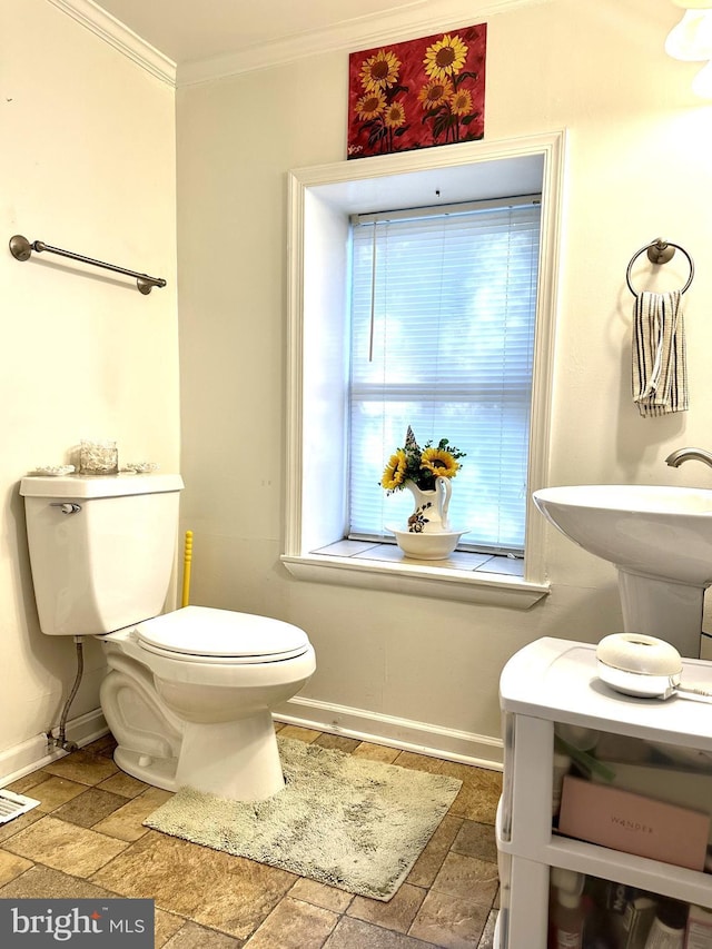 bathroom featuring crown molding, sink, and toilet