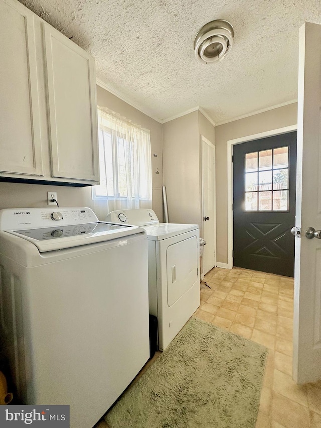 laundry area featuring washer and dryer, a healthy amount of sunlight, cabinets, and crown molding