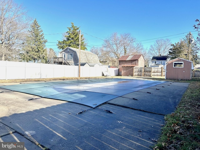 view of swimming pool with a storage shed and a patio