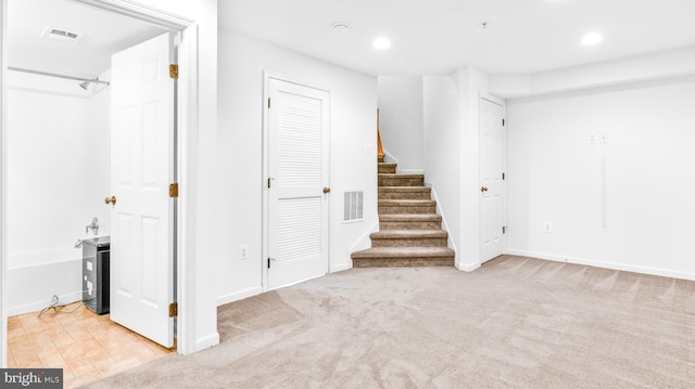 basement featuring light carpet