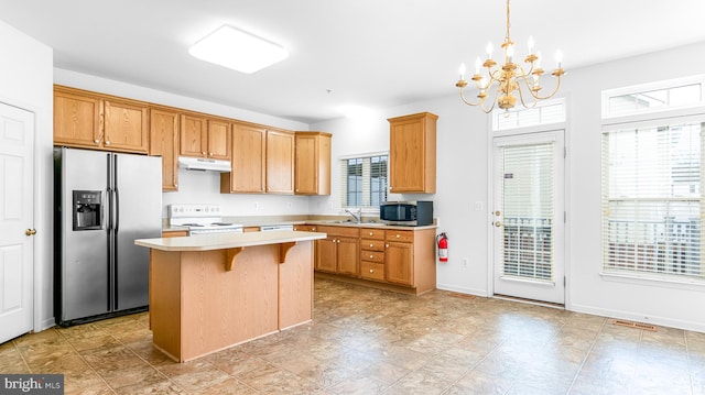 kitchen with a kitchen bar, sink, hanging light fixtures, a kitchen island, and stainless steel appliances