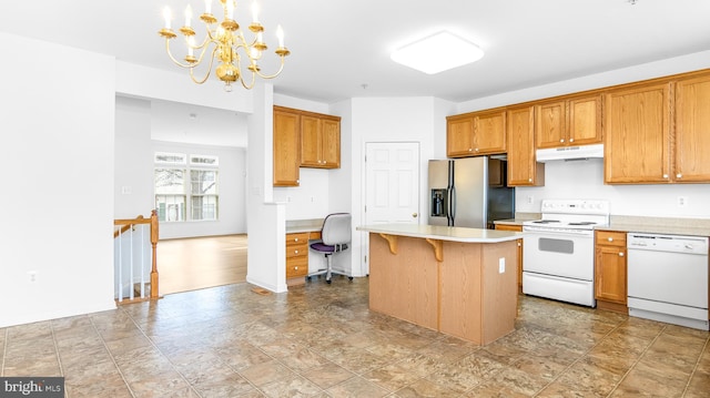 kitchen with white appliances, a center island, built in desk, a kitchen bar, and decorative light fixtures