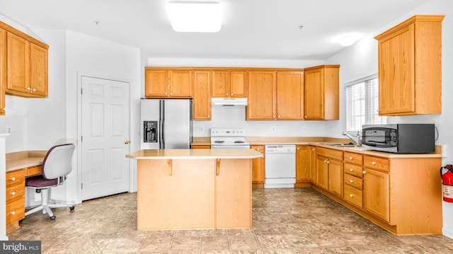 kitchen featuring white appliances, a breakfast bar area, sink, and a kitchen island