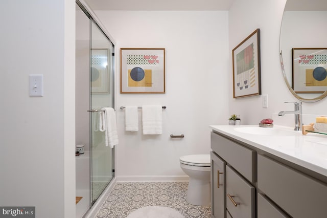 bathroom with tile patterned floors, vanity, toilet, and an enclosed shower