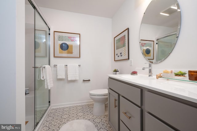 bathroom featuring tile patterned floors, vanity, toilet, and a shower with shower door