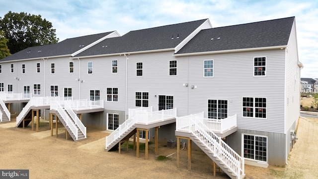 back of property with central AC unit and a deck