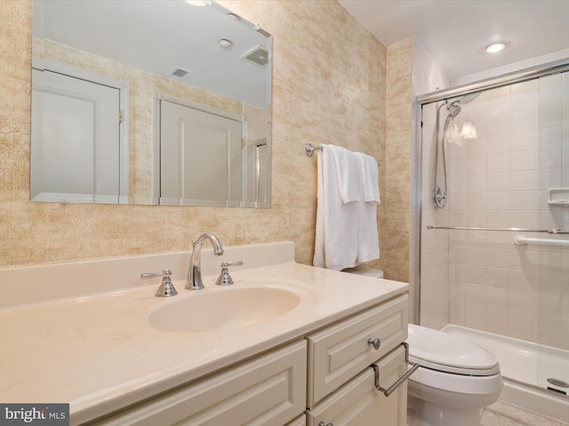 bathroom featuring vanity, toilet, and a shower with door