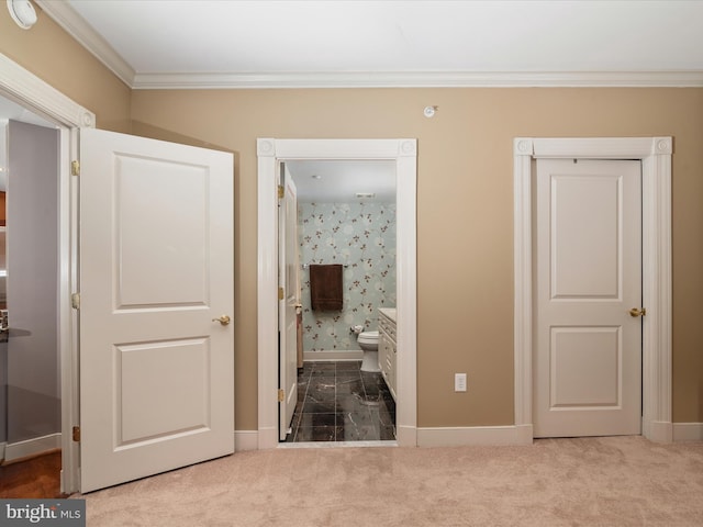 bedroom featuring carpet, ensuite bathroom, and ornamental molding