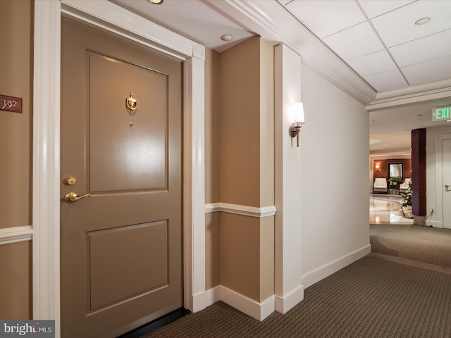 interior space featuring ornamental molding and dark colored carpet