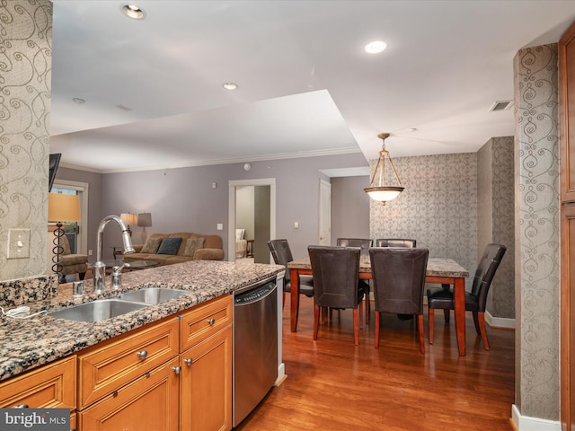 kitchen featuring stone counters, sink, hanging light fixtures, stainless steel dishwasher, and light wood-type flooring