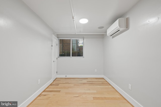 empty room with hardwood / wood-style floors and a wall unit AC