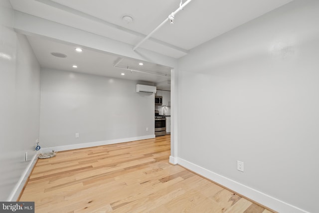 empty room featuring a wall unit AC and wood-type flooring