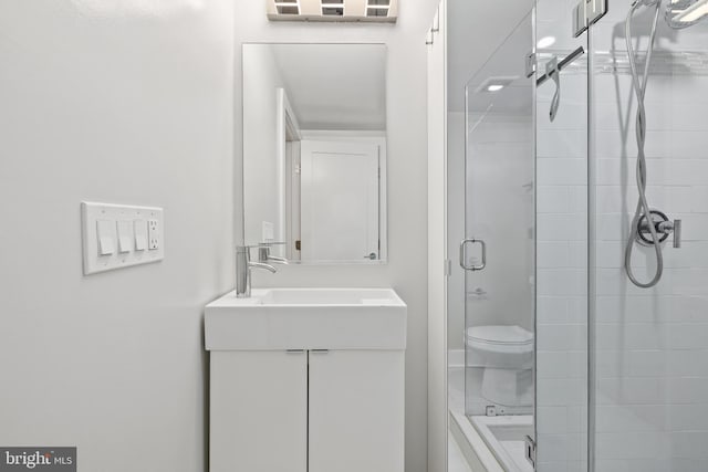 bathroom with vanity, an enclosed shower, and toilet