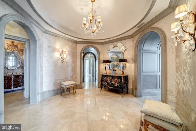 corridor featuring ornamental molding and an inviting chandelier