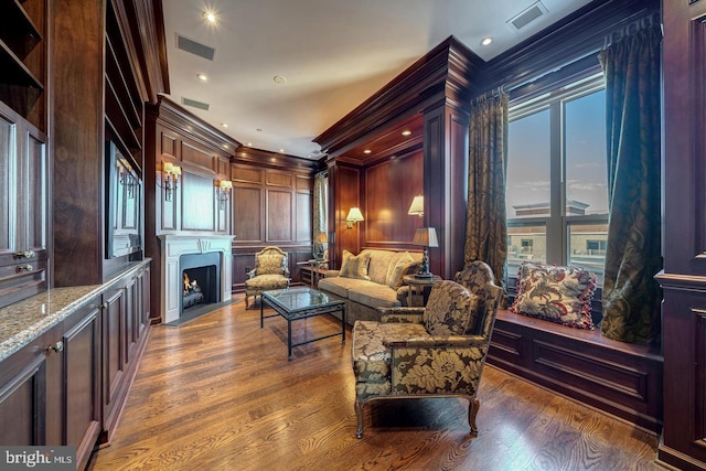 living area with dark hardwood / wood-style floors and crown molding