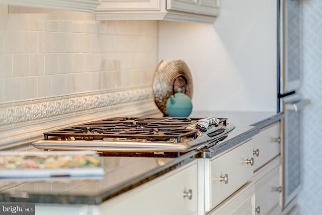 kitchen featuring white cabinets, decorative backsplash, and stainless steel gas cooktop