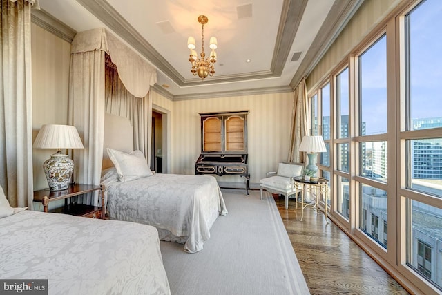 bedroom featuring hardwood / wood-style flooring, an inviting chandelier, multiple windows, and ornamental molding