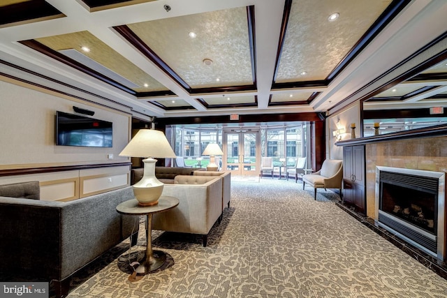 carpeted living room featuring french doors, ornamental molding, coffered ceiling, a tile fireplace, and beamed ceiling