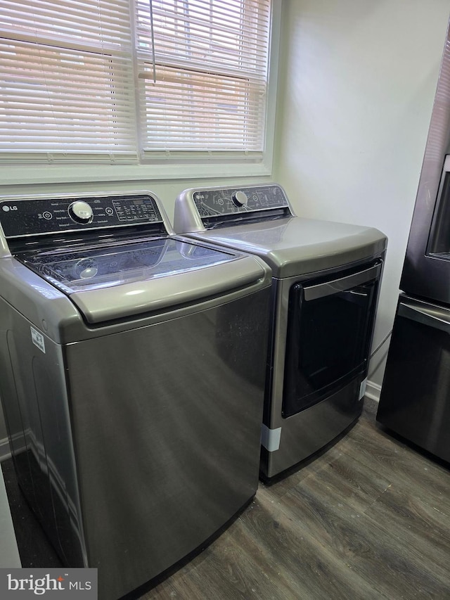 clothes washing area with separate washer and dryer and dark hardwood / wood-style flooring